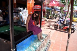 kate storm in a purple dress using a fish spa, a small part of trip to cambodia costs